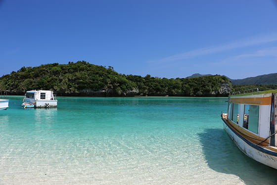 透き通った海の上に数台の船が浮いている様子