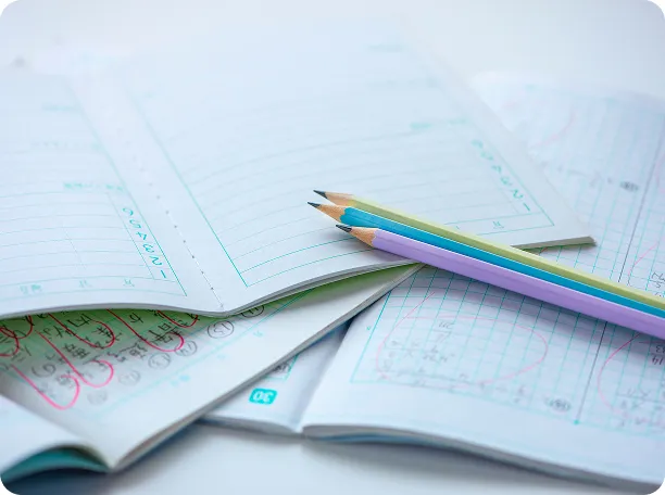 学習ノートと色鉛筆が置かれた机の上のクローズアップ